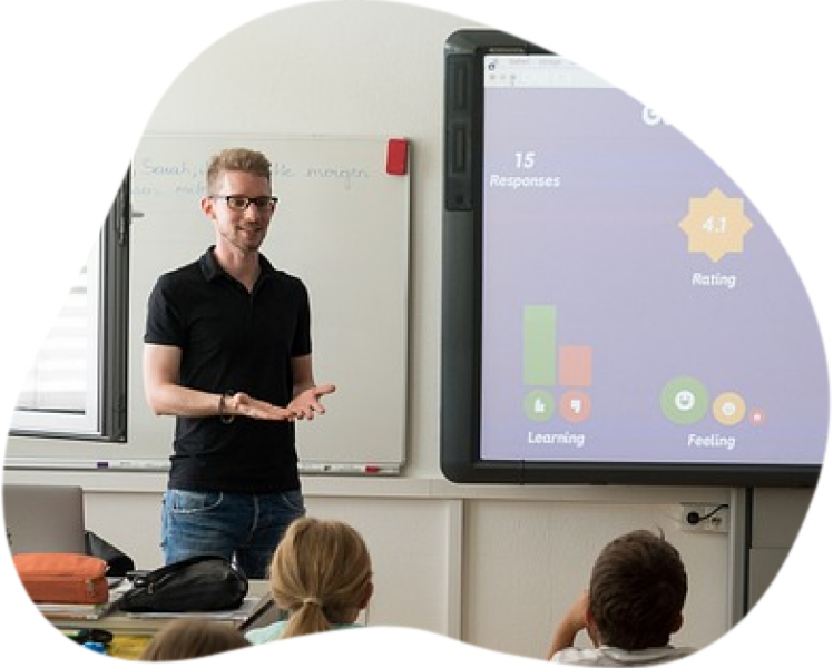 professor ao lado de projetor leciona aula de inglês para plateia de crianças