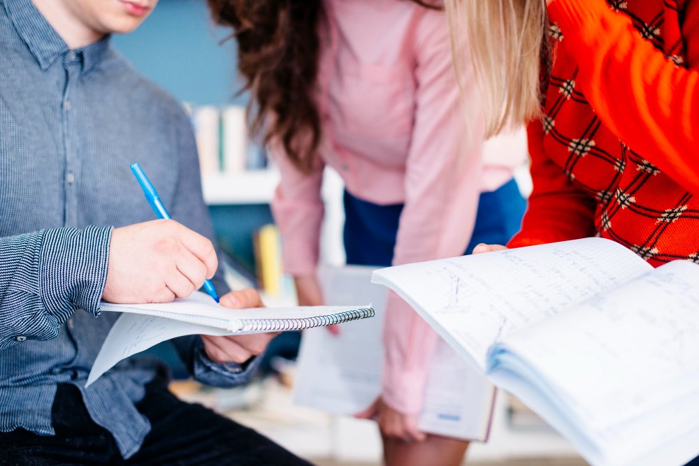 Colegas de sala reunidos para responder avaliação escolar