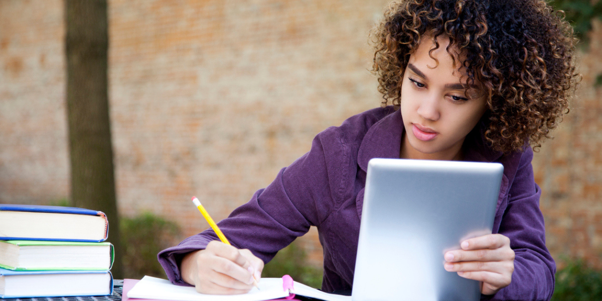 Estudante do ensino médio usando um tablet digital para estudar.