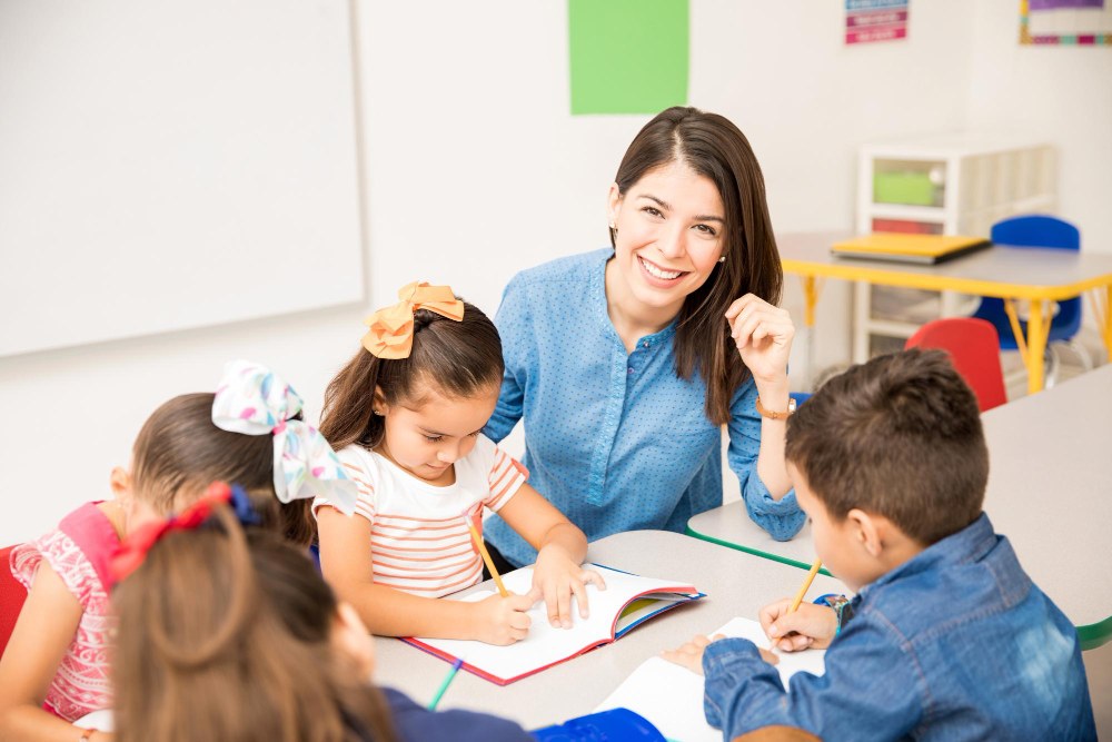 Professora ajudando crianças em atividade na sala de aula