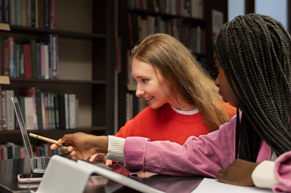 Duas meninas usando computador para estudar