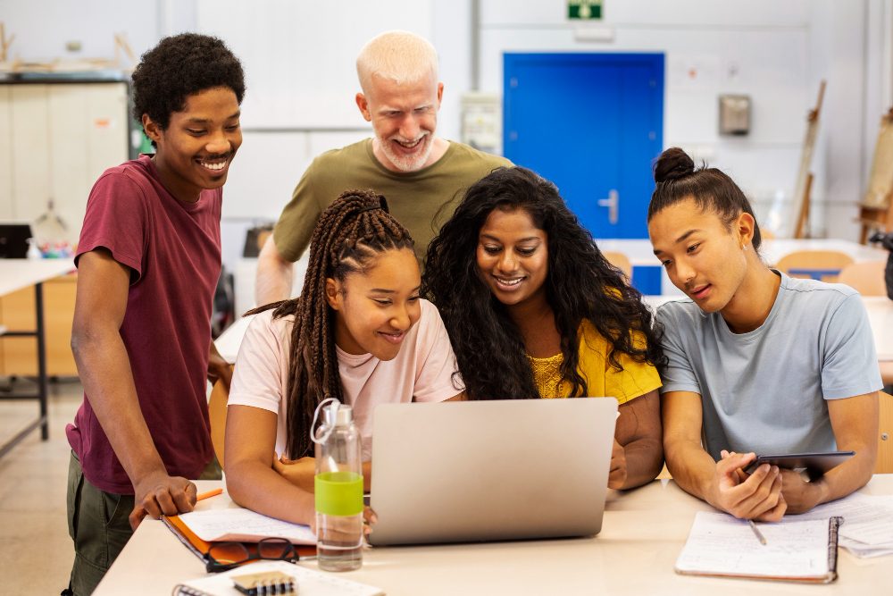 Alunos e professores usando juntos um computador para estudar.