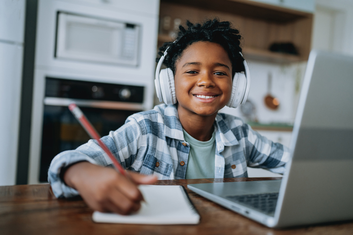 Portrait child boy studying at home on laptop