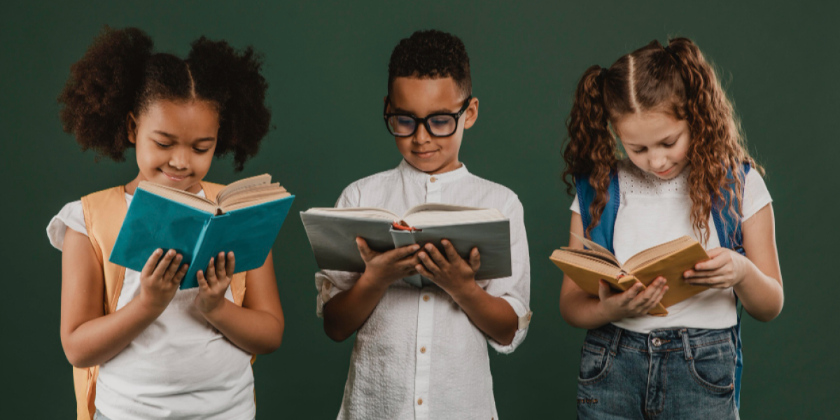 trio de crianças diversas composto por duas meninas e um menino em pé lado a lado lendo livros.